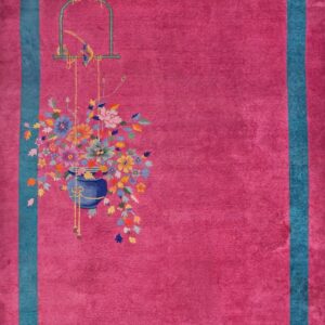 Magenta rug with teal border features a colorful bouquet and birdcage design on wooden flooring.