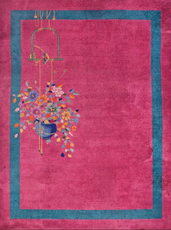 Magenta rug with teal border features a colorful bouquet and birdcage design on wooden flooring.