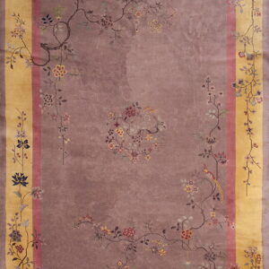 Low-pile rug with a mauve field, gold border, and a detailed sparse pattern of delicate floral branches.