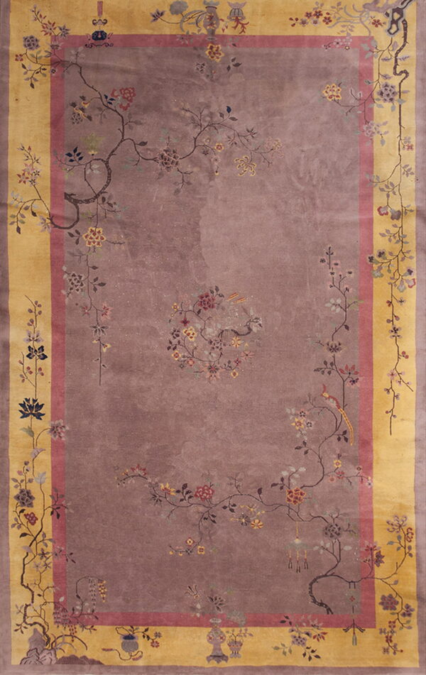 Low-pile rug with a mauve field, gold border, and a detailed sparse pattern of delicate floral branches.