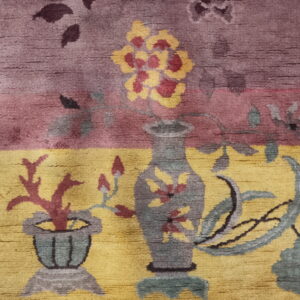 Pictorial rug detail featuring vases of yellow flowers and red coral on contrasting purple and gold fields.