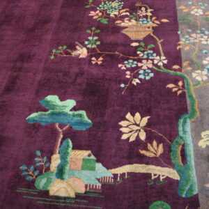 Plush purple rug with a gray stripe border and a detailed botanical scene of trees, flowers, and a structure.