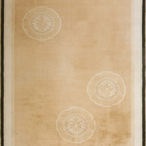 Low-pile tan rug with three cream medallions and layered borders of white, sage, and black.