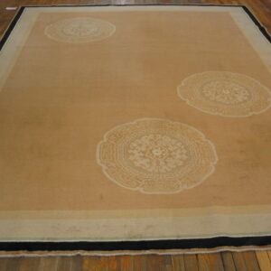 Tan rug with three large cream medallions featuring floral and geometric patterns, framed by a striped border.