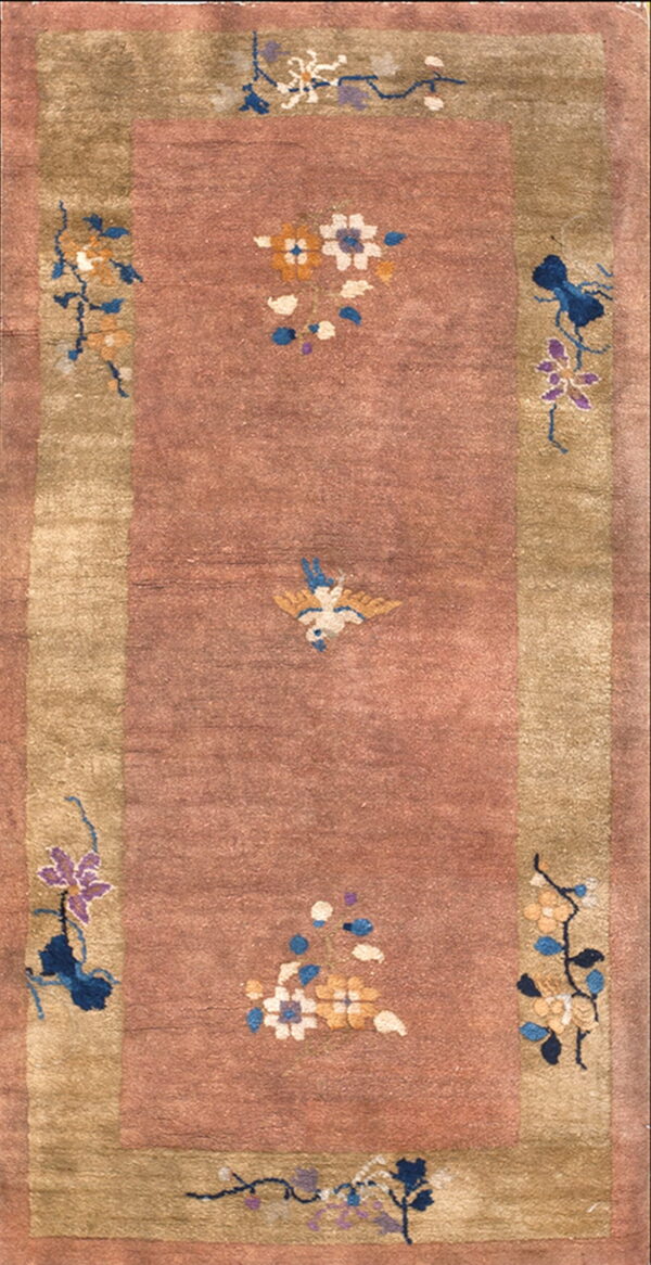 Muted rose rug with an olive border and scattered blue, white, and gold floral and bird designs.