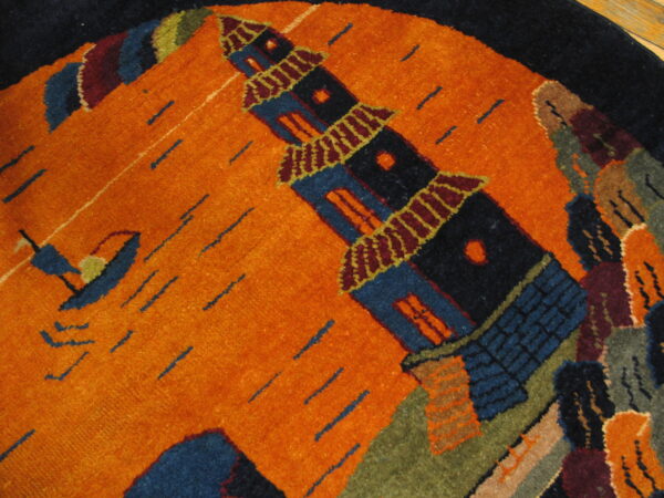 Orange round rug with a navy border featuring a detailed blue pagoda and a small stylized sailboat.