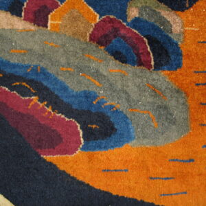High-pile rug with curvilinear abstract shapes in orange, navy, grey, blue, and maroon, accented by dash marks.
