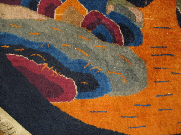 High-pile rug with curvilinear abstract shapes in orange, navy, grey, blue, and maroon, accented by dash marks.