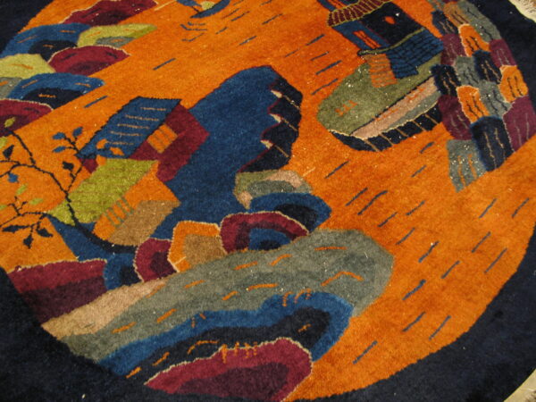 High-pile circular rug featuring an abstract orange field with large blue, green, and maroon stylized designs.