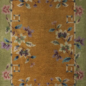 A rectangular rug featuring a gold field bordered by a sage green frame and colorful scrolling florals.