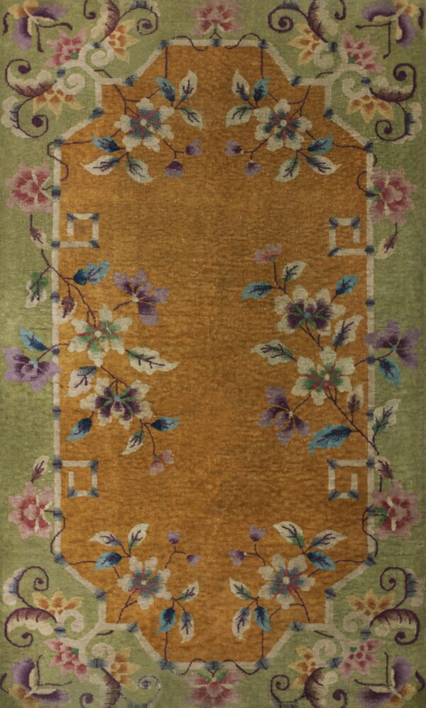 A rectangular rug featuring a gold field bordered by a sage green frame and colorful scrolling florals.