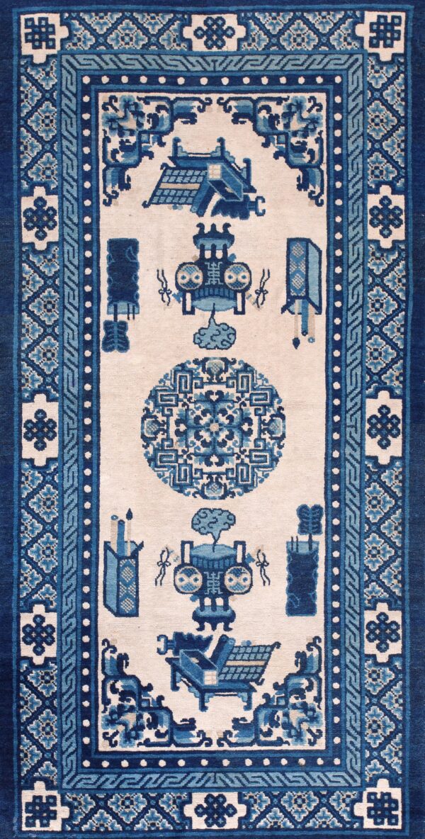 A rectangular runner rug in navy and light blue patterns against a light beige field on hardwood flooring.