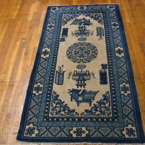 A blue and ivory runner rug with a central medallion and symbolic designs lays on a hardwood floor.