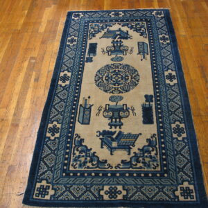 A navy blue and tan runner rug featuring stylized vases and geometric borders on warm wood flooring.