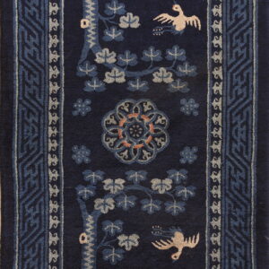 Long navy rug with light-colored deer and bird figures, surrounded by complex geometric borders.