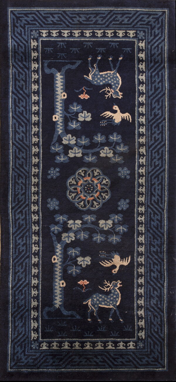 Long navy rug with light-colored deer and bird figures, surrounded by complex geometric borders.
