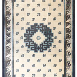 Cream rug featuring a central geometric medallion and key-pattern border in navy and light blue.