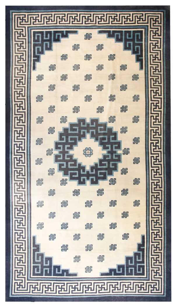 Cream rug featuring a central geometric medallion and key-pattern border in navy and light blue.