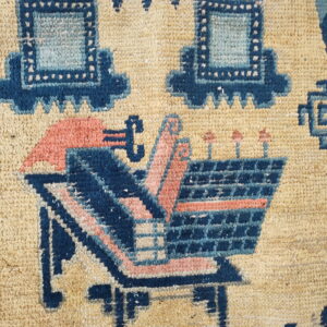 Tan rug detail featuring stylized structures and vessels in indigo, light blue, and coral pink.