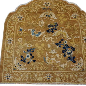Arched brown rug with navy blue and cream floral motifs, surrounded by complex tan borders.