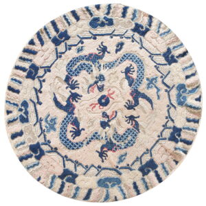 Round rug with a carved blue dragon design on a textured pale pink and beige background.