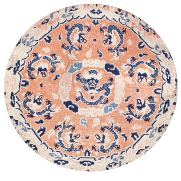 Circular rug with a coral field, featuring navy blue dragon motifs and light blue and cream accents.