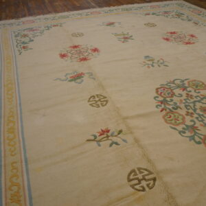 A cream low-pile rug featuring pastel floral motifs and Shou symbols rests on narrow wood plank flooring.