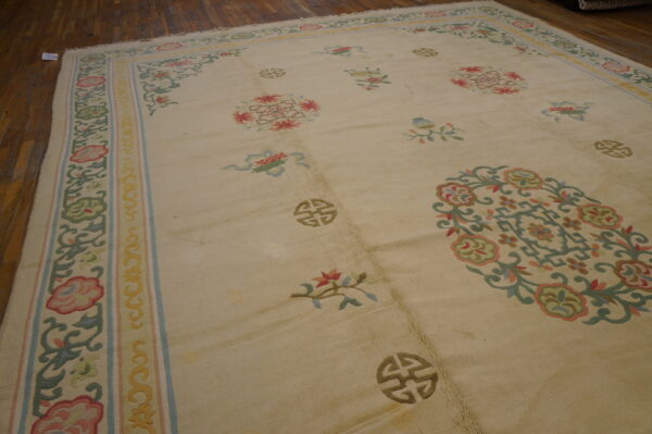 A cream low-pile rug featuring pastel floral motifs and shou symbols rests on narrow wood plank flooring.