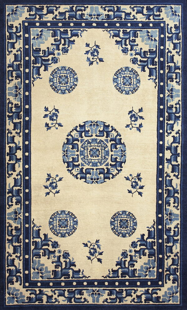 Cream rug with complex blue geometric medallions and a stylized wide blue border.