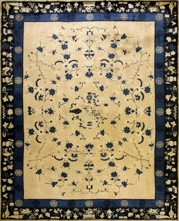 Cream field rug featuring a scattered blue vine design surrounded by a detailed black and navy border.