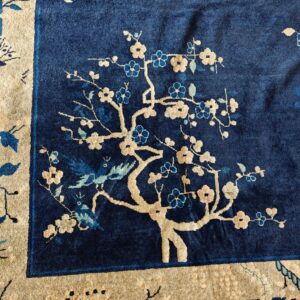 High-pile navy rug with a beige and blue floral tree motif and a wide cream border pattern.