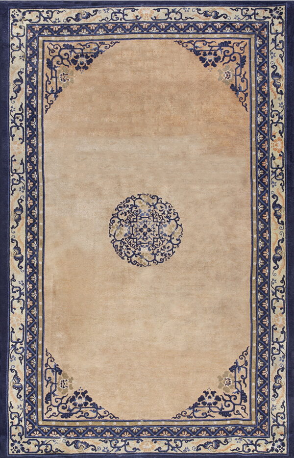 Beige rug with a central blue medallion and complex, wide navy blue and tan ornamental borders.