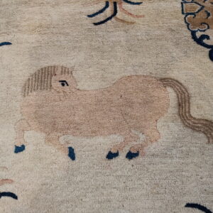 Close-up of a textured beige rug showing a tan horse pattern with blue and brown details.