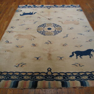 Cream field rug featuring stylized blue and light tan horses, a central medallion, and complex cloud borders on a wood floor.