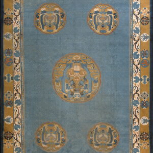 A large blue and gold rug featuring a field of subtle key patterns and five detailed roundel medallions.