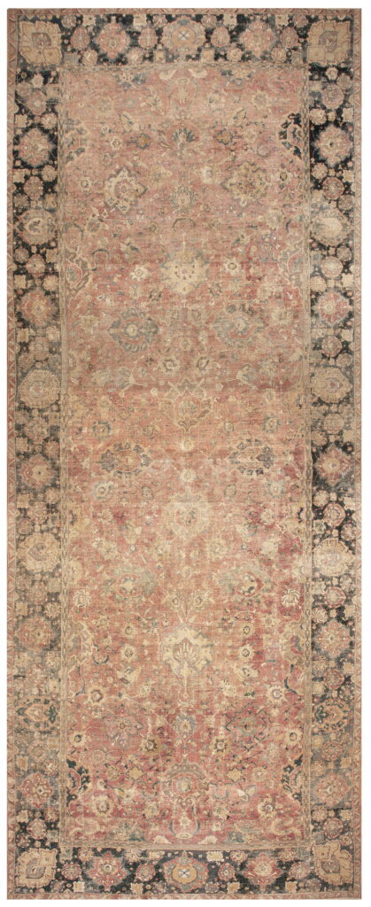 Faded, low-pile rug featuring a rose-red central field and wide dark borders with traditional floral patterning.