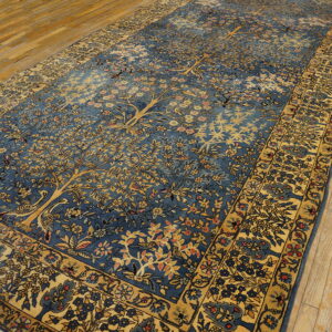 Long blue rug with golden botanical Tree of Life design displayed on a distressed wooden floor.