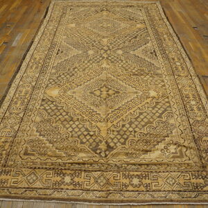Sepia-toned geometric rug featuring a detailed central medallion lying on worn hardwood floors.