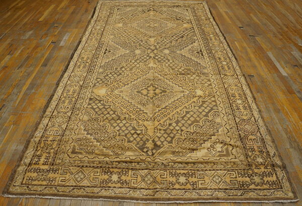 Sepia-toned geometric rug featuring a detailed central medallion lying on worn hardwood floors.