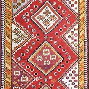 Long runner rug featuring a continuous chain of colorful geometric diamonds on a vibrant red field.