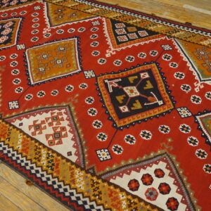 Low-pile red rug runner featuring large, detailed geometric medallions and small stars on wood planks.