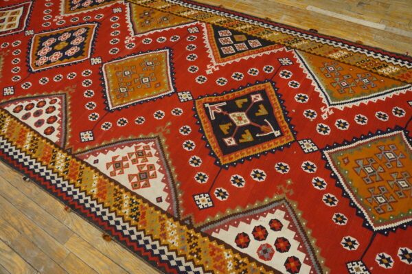 Low-pile red rug runner featuring large, detailed geometric medallions and small stars on wood planks.