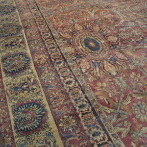 A detailed rug featuring red, cream, and blue traditional floral patterns and distinct borders.