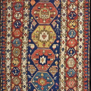 Detailed geometric runner rug in navy, red, yellow, and ivory with repeating hexagonal patterns and multiple borders.