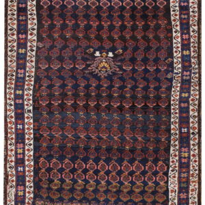 A dark blue rug featuring rows of repeating red geometric medallions and a complex multi-band border.