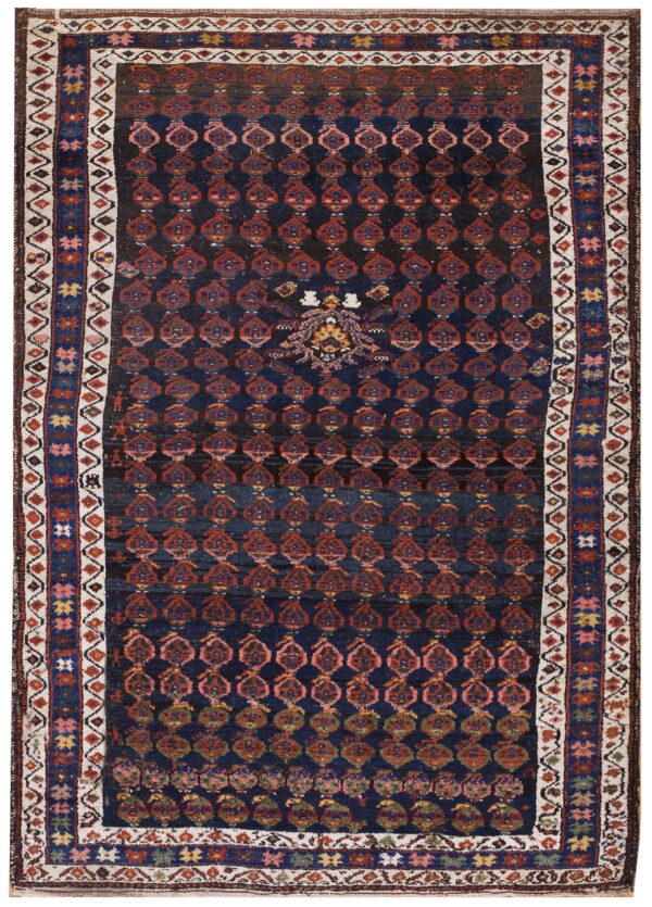 A dark blue rug featuring rows of repeating red geometric medallions and a complex multi-band border.