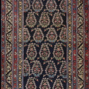 Dark indigo runner rug with an all-over repeating diamond floral pattern and complex multicolored borders.