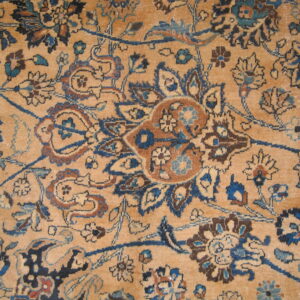 Distressed tan rug with a dense traditional pattern in deep blue, light blue, and russet brown.