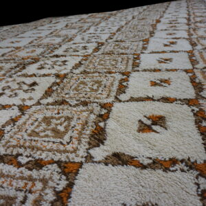Shaggy rug with a large-scale cream and brown geometric grid accented with bright orange.