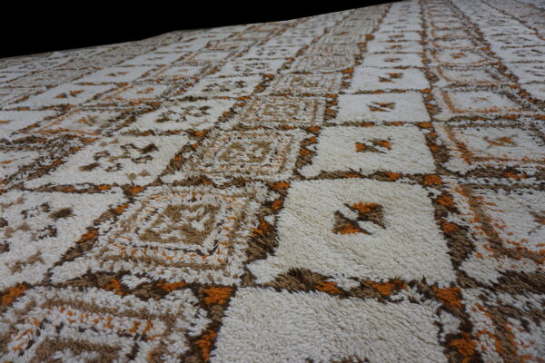 Shaggy rug with a large-scale cream and brown geometric grid accented with bright orange.